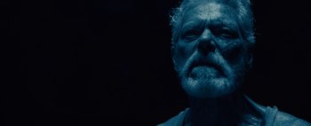 Movie still from “Don't Breathe 2” (2021), directed by Rodo Sayagues – An old man with a gray beard is looking at the camera; Close Up shot, Low angle