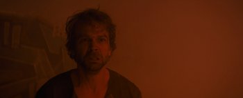 Movie still from “Don't Breathe 2” (2021), directed by Rodo Sayagues – A man in a dark room looking at the camera; Close Up shot, Low angle