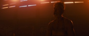 Movie still from “Don't Breathe 2” (2021), directed by Rodo Sayagues – A man in a white shirt is in a dark room; Close Up shot, Low angle