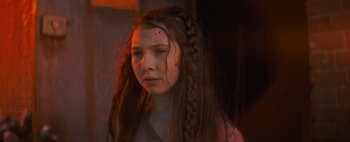 Movie still from “Don't Breathe 2” (2021), directed by Rodo Sayagues – A young girl with long brown hair and red spots on her face; Close Up shot, Low angle