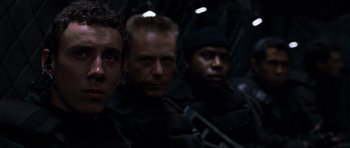 Movie still from “Doom” (2005), directed by Andrzej Bartkowiak – A group of men standing next to each other in the dark; Close Up shot, Over the shoulder angle