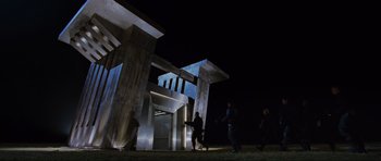 Movie still from “Doom” (2005), directed by Andrzej Bartkowiak – A group of people standing around a building at night; Extreme Wide shot, Low angle