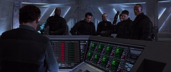 Movie still from “Doom” (2005), directed by Andrzej Bartkowiak – A group of men sitting next to each other in front of a computer screen; Medium shot, Over the shoulder angle