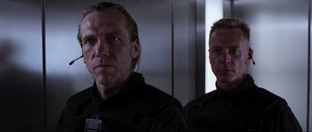 Movie still from “Doom” (2005), directed by Andrzej Bartkowiak – Two men in black uniforms are standing next to each other; Close Up shot, Low angle