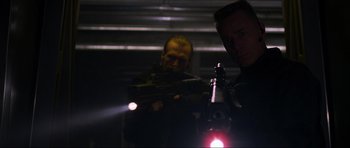 Movie still from “Doom” (2005), directed by Andrzej Bartkowiak – A man holding a gun in front of another man; Medium shot, Low angle