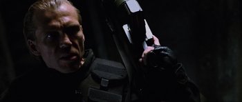 Movie still from “Doom” (2005), directed by Andrzej Bartkowiak – A man in a black jacket holding a camera; Close Up shot, Low angle