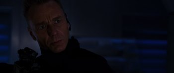 Movie still from “Doom” (2005), directed by Andrzej Bartkowiak – A man wearing a black jacket is looking at the camera; Close Up shot, Low angle