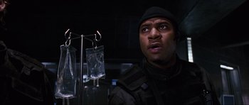 Movie still from “Doom” (2005), directed by Andrzej Bartkowiak – A man in black jacket looking up in a dark room; Close Up shot, Low angle