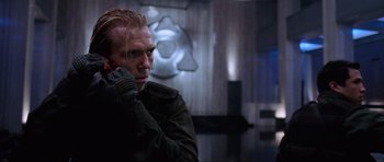 Movie still from “Doom” (2005), directed by Andrzej Bartkowiak – A man in a green jacket is talking on a phone; Close Up shot, Over the shoulder angle