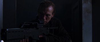 Movie still from “Doom” (2005), directed by Andrzej Bartkowiak – A man with a gun in a dark room; Close Up shot, Low angle