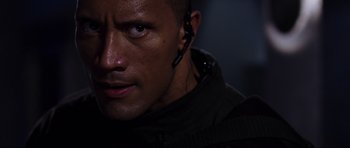 Movie still from “Doom” (2005), directed by Andrzej Bartkowiak – Close up of a man wearing a black jacket and ear buds; Close Up shot, High angle