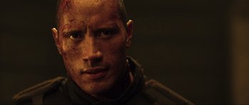 Movie still from “Doom” (2005), directed by Andrzej Bartkowiak – A person with a face covered in dirt; Close Up shot, Over the shoulder angle