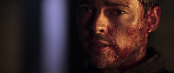 Movie still from “Doom” (2005), directed by Andrzej Bartkowiak – A person with blood all over his face; Close Up shot, Over the shoulder angle