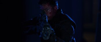 Movie still from “Doom” (2005), directed by Andrzej Bartkowiak – A man in a black jacket is holding a gun; Close Up shot, Low angle