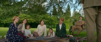 Movie still from “Downton Abbey: A New Era” (2022), directed by Simon Curtis – A group of people sitting on a blanket in the grass; Medium shot, High angle