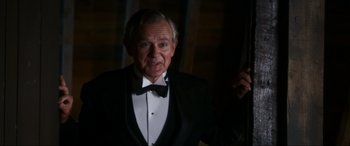 Movie still from “Downton Abbey: A New Era” (2022), directed by Simon Curtis – An older man wearing a tuxedo and a bow tie; Close Up shot, Over the shoulder angle