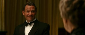 Movie still from “Downton Abbey: A New Era” (2022), directed by Simon Curtis – A man in a tuxedo smiling for the camera; Close Up shot, Low angle