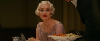 Movie still from “Downton Abbey: A New Era” (2022), directed by Simon Curtis – A woman in a purple dress sitting at a table; Close Up shot, Over the shoulder angle