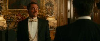 Movie still from “Downton Abbey: A New Era” (2022), directed by Simon Curtis – A man in a tuxedo standing in front of a mirror; Medium shot, Over the shoulder angle