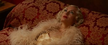 Movie still from “Downton Abbey: A New Era” (2022), directed by Simon Curtis – A woman with blonde hair wearing a white dress and a feather boa; Close Up shot, High angle