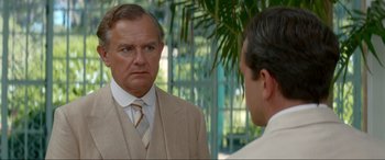 Movie still from “Downton Abbey: A New Era” (2022), directed by Simon Curtis – A man wearing a suit and tie talking to another man; Close Up shot, Over the shoulder angle