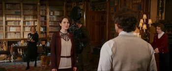 Movie still from “Downton Abbey: A New Era” (2022), directed by Simon Curtis – A woman standing in front of a man in front of a camera; Medium shot, Over the shoulder angle