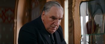 Movie still from “Downton Abbey: A New Era” (2022), directed by Simon Curtis – An older man wearing a suit and tie looking sad; Close Up shot, Low angle