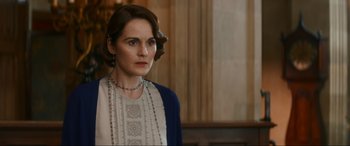 Movie still from “Downton Abbey: A New Era” (2022), directed by Simon Curtis – A woman in a white and blue dress looking to her left; Close Up shot, Over the shoulder angle