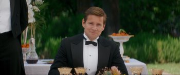 Movie still from “Downton Abbey: A New Era” (2022), directed by Simon Curtis – A man in a tuxedo sitting at a table; Medium shot, Over the shoulder angle