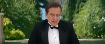 Movie still from “Downton Abbey: A New Era” (2022), directed by Simon Curtis – A person wearing a suit and a bow tie; Close Up shot, Over the shoulder angle