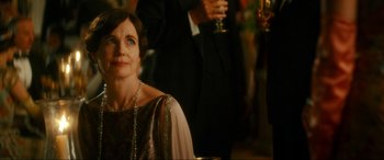 Movie still from “Downton Abbey: A New Era” (2022), directed by Simon Curtis – A woman sitting in front of a man holding a glass; Close Up shot, Over the shoulder angle