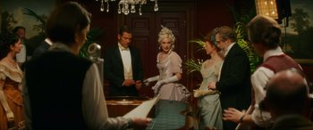 Movie still from “Downton Abbey: A New Era” (2022), directed by Simon Curtis – A group of people standing around a table; Medium shot, Low angle
