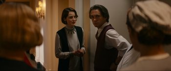 Movie still from “Downton Abbey: A New Era” (2022), directed by Simon Curtis – A man and a woman standing next to each other in a room; Medium shot, Over the shoulder angle