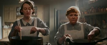 Movie still from “Downton Abbey: A New Era” (2022), directed by Simon Curtis – Two women are cooking in a kitchen; Medium shot, Low angle
