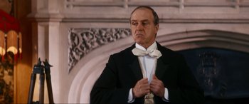 Movie still from “Downton Abbey: A New Era” (2022), directed by Simon Curtis – An older man wearing a tuxedo and bow tie; Medium shot, Low angle