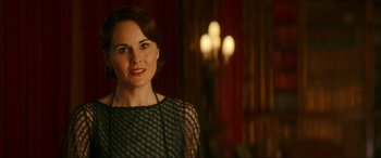 Movie still from “Downton Abbey: A New Era” (2022), directed by Simon Curtis – A woman in a black dress standing in front of a chandelier; Close Up shot, Over the shoulder angle