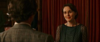 Movie still from “Downton Abbey: A New Era” (2022), directed by Simon Curtis – A woman in a black dress is smiling at the camera; Close Up shot, Over the shoulder angle