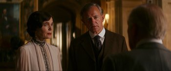 Movie still from “Downton Abbey: A New Era” (2022), directed by Simon Curtis – A man and a woman standing next to each other in a room; Medium shot, Over the shoulder angle