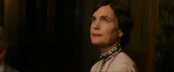 Movie still from “Downton Abbey: A New Era” (2022), directed by Simon Curtis – An older woman wearing a white shirt and a black and white necklace; Close Up shot, Low angle