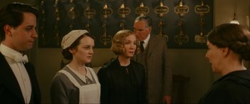 Movie still from “Downton Abbey: A New Era” (2022), directed by Simon Curtis – Two women and a man standing next to each other in a room; Medium shot, Over the shoulder angle