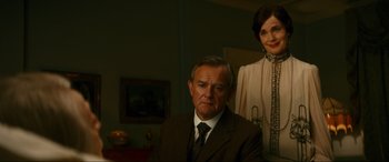 Movie still from “Downton Abbey: A New Era” (2022), directed by Simon Curtis – An older man and a younger woman pose for a picture; Medium shot, Low angle