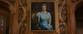 Movie still from “Downton Abbey: A New Era” (2022), directed by Simon Curtis – An older woman wearing a blue dress sitting in a chair; Medium shot, Low angle