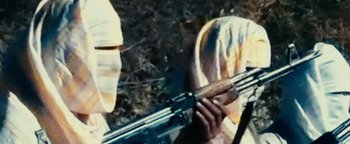 Movie still from “12 Strong” (2018), directed by Nicolai Fuglsig – A person holding a rifle in a field; Extreme Close Up shot, Low angle