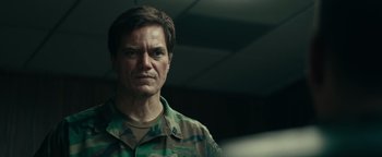 Movie still from “12 Strong” (2018), directed by Nicolai Fuglsig – A person wearing a military uniform; Close Up shot, Over the shoulder angle