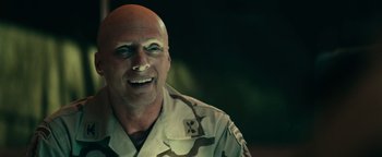 Movie still from “12 Strong” (2018), directed by Nicolai Fuglsig – A man in a military uniform smiling for the camera; Close Up shot, Over the shoulder angle