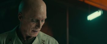 Movie still from “12 Strong” (2018), directed by Nicolai Fuglsig – A bald man with a cross on his head; Close Up shot, Over the shoulder angle