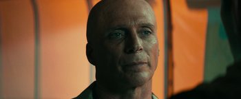 Movie still from “12 Strong” (2018), directed by Nicolai Fuglsig – A bald man with green eyes stares straight ahead; Close Up shot, Low angle