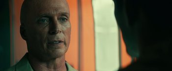 Movie still from “12 Strong” (2018), directed by Nicolai Fuglsig – An older man with a bald head looking into a mirror; Close Up shot, Over the shoulder angle