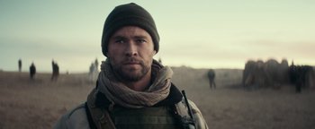 Movie still from “12 Strong” (2018), directed by Nicolai Fuglsig – A man with a beard and a hat on; Close Up shot, Over the shoulder angle