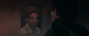 Movie still from “12 Strong” (2018), directed by Nicolai Fuglsig – A man looking at a picture of a man with a beard; Close Up shot, Over the shoulder angle